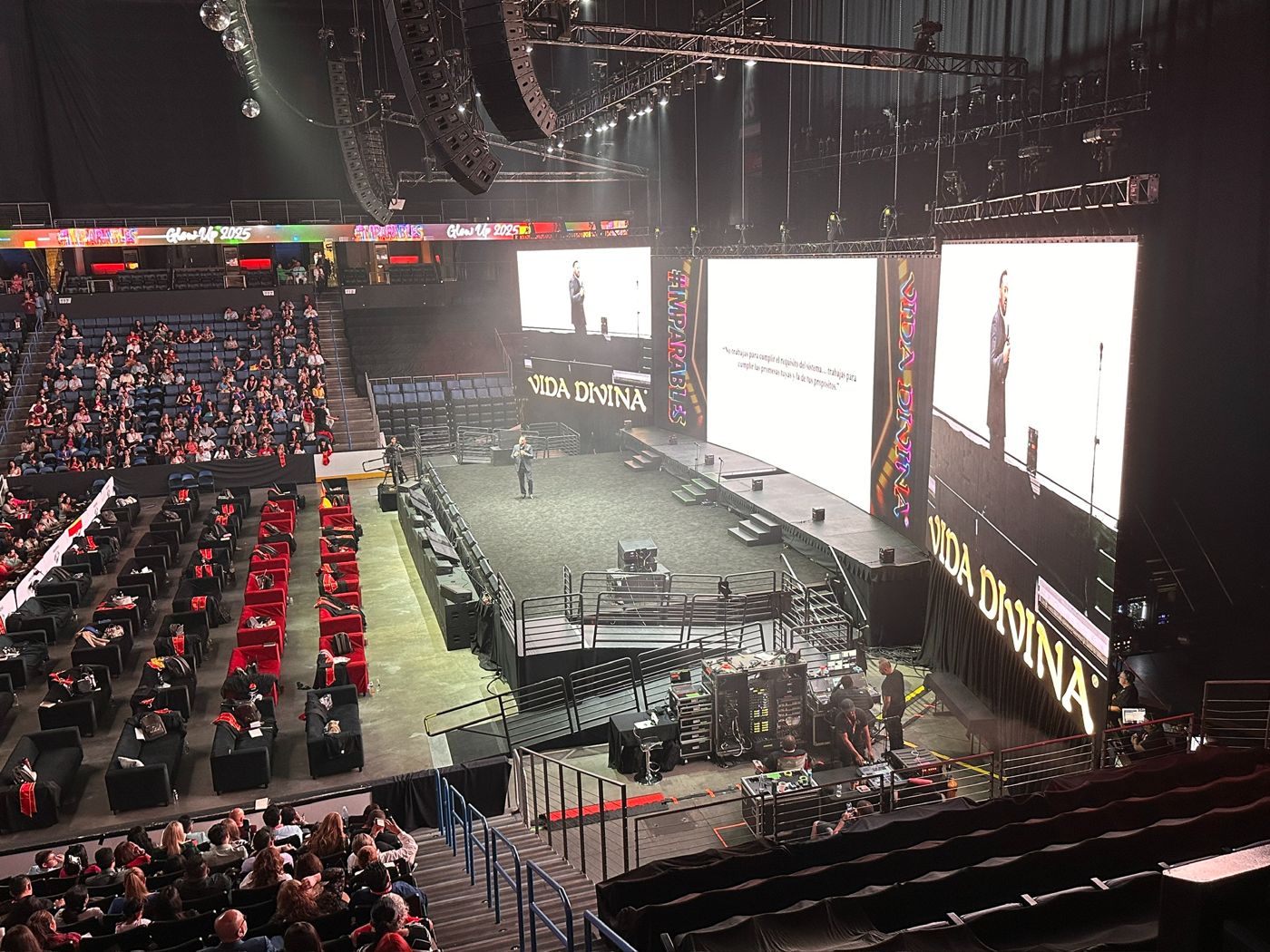 Arena conference with three large LED screens, a long stage and a full line array